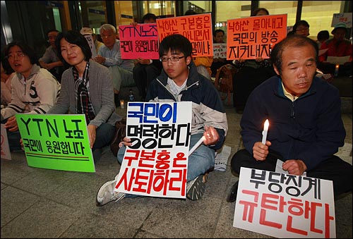 7일 저녁 서울 남대문로 YTN사옥앞에서 열린 촛불문화제에서 누리꾼들이 대량징계 철회를 요구하며 손피켓을 들어보이고 있다.