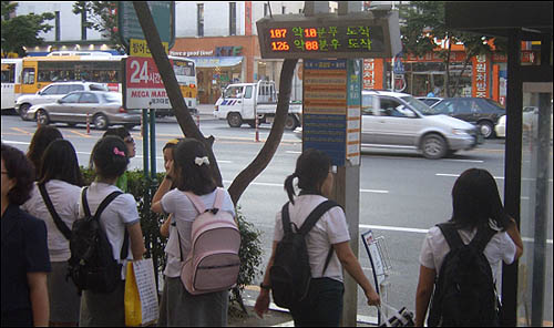 등굣길에 버스를 기다리는 학생들