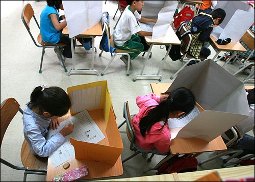 초등학교 3학년 학생들을 대상으로 일제고사가 치러진 작년 10월 8일 오전 서울 미동초등학교 3학년 학생들이 가림막을 친 가운데 시험문제를 풀고 있다.