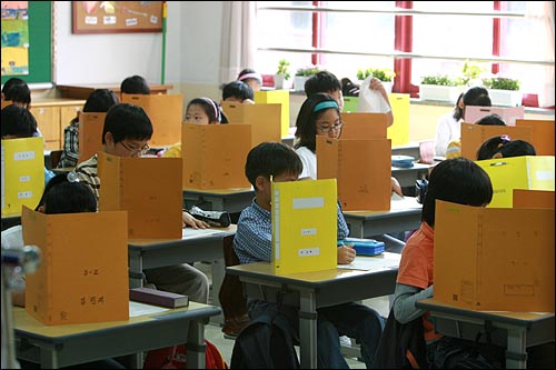 초등학교 3학년 학생들을 대상으로 일제고사가 치러진 지난해 10월8일 오전 서울 미동초등학교 3학년 학생들이 가림막을 친 가운데 시험문제를 풀고 있다.