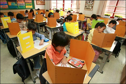 초등학교 3학년 학생들을 대상으로 일제고사가 치러진 2008년 10월 8일 오전 서울 미동초등학교 3학년 학생들이 가림막을 친 가운데 시험문제를 풀고 있다.