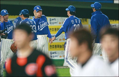  삼성 선동렬 감독이 8일 저녁 사직야구장에서 열린 2008 프로야구 준플레이오프 1차전 롯데와의 경기에서 12대 3으로 승리한 뒤 선수들과 하이파이브를 하고 있다.