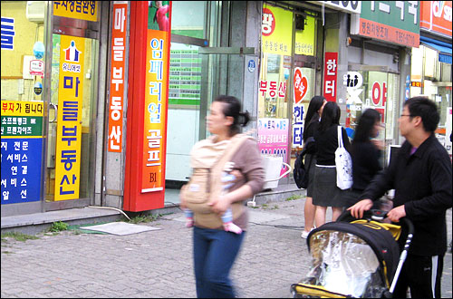서울 노원구 중계동 은행사거리는 학원가라는 특수성 때문에 집 값의 등락폭이 크지 않다. 사진은 학원이 밀집해 있는 상가 건물 1층에 위치한 공인중개업소에 눈길을 보내고 있는 시민들.