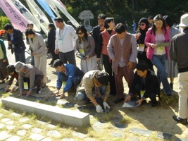 벽초 홍명희 기념비 앞에서 통일 노둣돌을 놓고 있는 한국작가회의 회원들