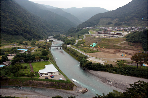 구마모토 가와베강댐이 건설될 경우 수몰될 예정이었던 이츠키마을. 이미 보상과 공사가 끝나 원래 마을과 학교는 댐건설 시 예상수위 위쪽(사진 오른쪽 위)으로 옮겨졌고, 일부 주민들은 고향을 떠났다.