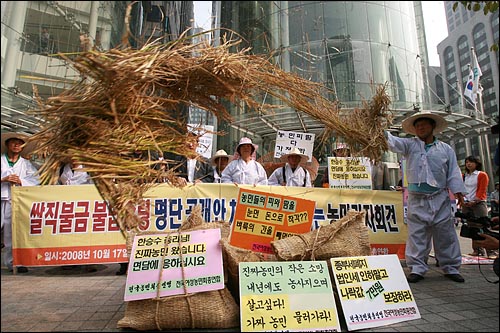 경찰의 저지로 총리실까지 행진이 무산되자 농민들이 가져온 벼를 뿌리며 항의하고 있다.