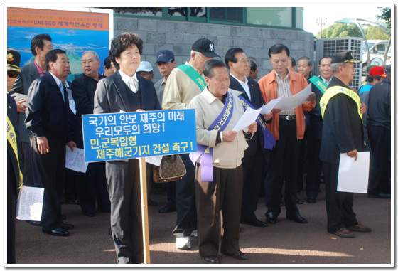 해군기지 찬성 집회 집회에 참여한 회원들이 전단을 나눠 읽고 있다.