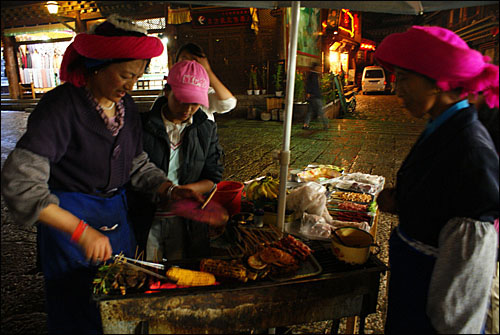 티베트인의 거주지였던 고성 쓰팡제(四方街)에서 쓰촨식 구이요리를 파는 한 티베트 여인. 밀물 듯이 들어오는 중국 문화의 영향으로 오늘날 샹그릴라 티베트인들은 중국 요리를 즐긴다.