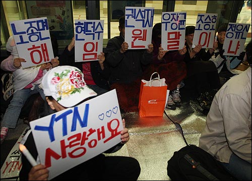  시민들이 24일 저녁 YTN 구본홍 사장 출근저지 투쟁 100일을 기념하며 서울 남대문로 YTN사옥 앞에서 연 촛불문화제에 참가해 정부의 언론자유 탄압을 규탄하며 손피켓을 들어보이고 있다.