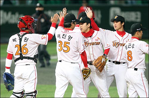  SK 선수들이 27일 저녁 인천 문학야구장에서 열린 2008 프로야구 한국시리즈 2차전 두산과의 경기에서 5대 2로 승리한 뒤 팀동료들과 하이파이브를 하고 있다.