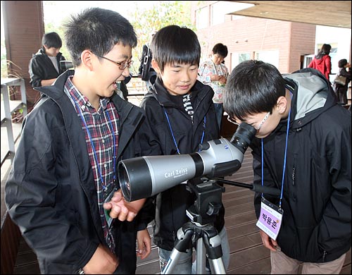 시골의 `나홀로 6학년' 학생들이 모여 서울로 `더불어 졸업여행'을 온 둘째날인 5일 오후 강화도 갯벌체험에 나서 망원경으로 갯벌을 보고 있다.
