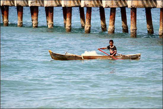 딜리 앞바다에서 작은 배에 그물을 싣고 고기잡이에 나선 아이. 고기잡이는 해안가에 사는 동티모르 주민들의 주 수입원이다.