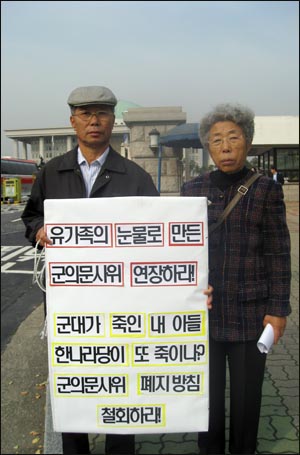 군의문사 유가족들이 14일 서울 여의도 국회의사당 앞에서 피켓시위를 벌이고 있다.