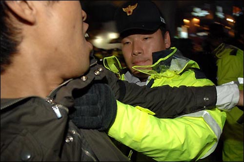 시민 500여 명이 15일 저녁 서울 명동에서 "이명박 대통령 퇴진" 등의 구호를 외치며 시위를 벌이자, 경찰이 이를 진압하고 있다. 경찰은 시위대 연행 과정에서 촬영하던 <통일뉴스> 사진기자의 멱살을 잡으며 취재를 방해했다.