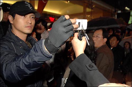 명동 골목에 투입된 사복경찰이 핸드폰으로 시민들의 모습을 촬영하며 채증하고 있다.