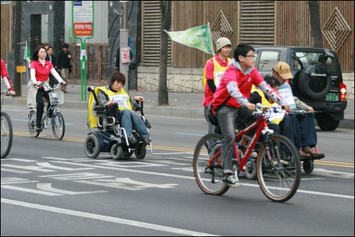 자전거도시만들기 대행진에 참여한 장애인. 그들은 가슴에 '바퀴가 웃는 도시를 만들어요'를 새기고 참여했다. 자전거도시는 사람의 도시일 수밖에 없는  이유가 여기에 있다.
