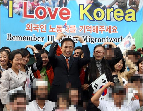 이명박 대통령이 대통령후보 시절이었던 2007년 10월 12일 오후 경기도 남양주시 외국인근로자복지센터에서 열린 한나라당 타운미팅 '한국의 특별한 며느리들' 행사를 마친 뒤 다문화가정 주부, 이주노동자들과 기념촬영을 하며 하트를 만들고 있다.