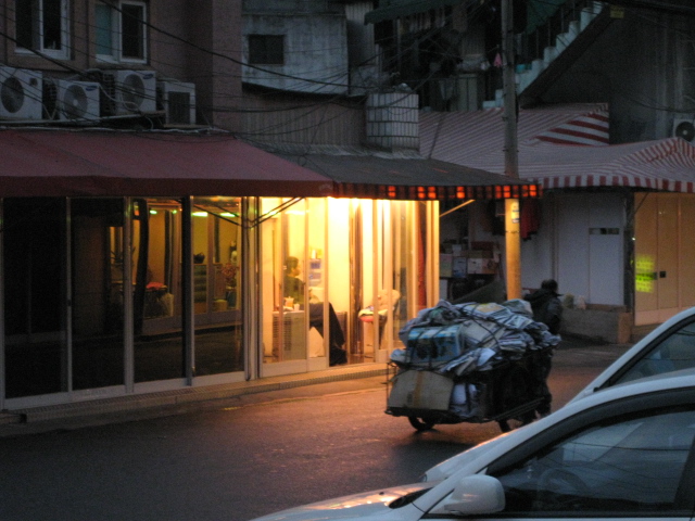 폐지를 잔뜩 실은 수레가 지나가네요. 그 앞에 불이 켜져 있네요. 빈민과 성노동자, 가슴 시린 서울의 모습입니다. 