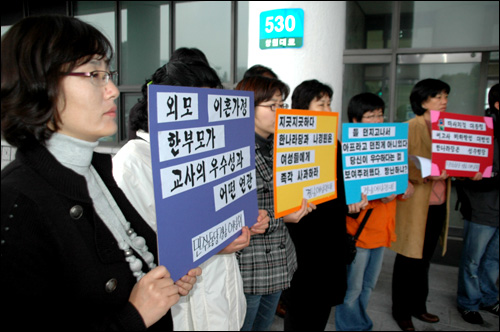 경남지역 여성단체 회원들이 창원국가산업단지 동남지역본부 현관 앞에서 피켓을 들고 서 있다.