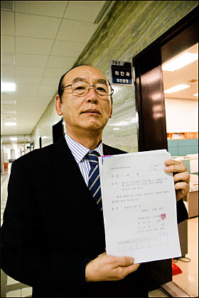 김용길 한국원폭피해자협회장이 국회 의안과에 법안을 제출하기 앞서 법안을 들어 보이고 있다.