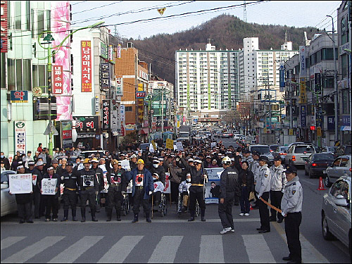 전직 광부들이 펼침막을 들고 거리행진을 하고 있다.