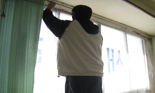 쫄대를 벽에 붙여놓고 그 위에 비닐을 통하여 바람막이 공사를 하고 있다.