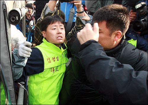 탈북자인 자유북한운동연합 회원이 진보연대 회원을 향해 스패너를 휘두르며 위협하고 있다.