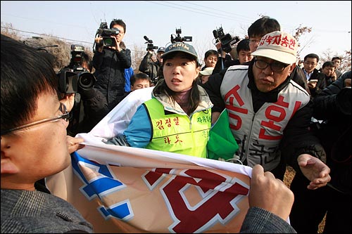  진보연대 회원들이 대북전단 10만장을 날려보내려는 자유북한운동연합과 납북자가족모임 회원들이 자유의다리에 들어가지 못하도록 입구를 막고 있다.