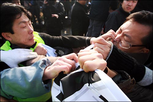 탈북자인 자유북한운동연합 박상학 대표(왼쪽)가 진보연대 회원과 몸싸움을 벌이고 있다.