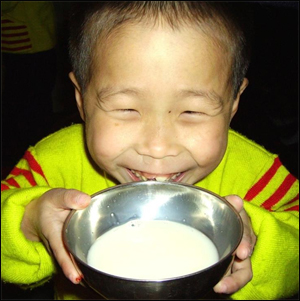 두유를 마시며 웃고 있는 북한 어린이