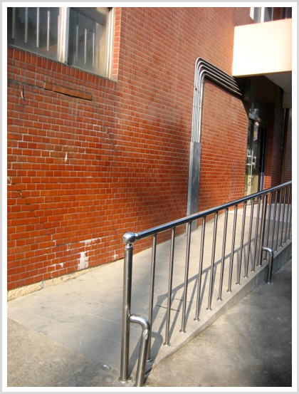 휄체어가 이동하기 편리하도록 학교의 출입구에 설치된 경사면의 모습이다.