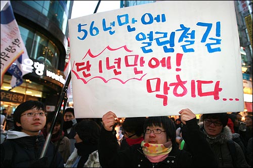 6일 저녁 서울 명동에서 민주민생국민회의 주최로 열린 '경제파탄 민주파괴 이명박 정권 심판 국민대회'에서 한 참가자가 경의선 남북열차 운행 중단을 안타까워하는 피켓을 들고 있다.