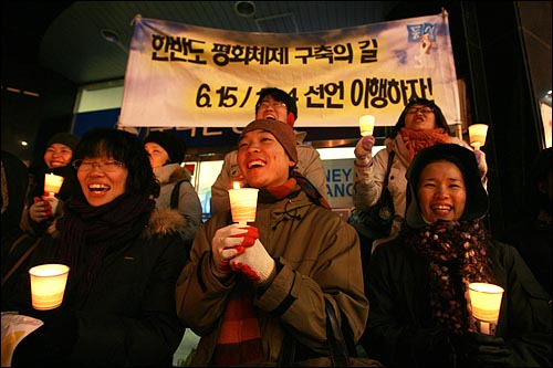 6일 저녁 서울 명동에서 민주민생국민회의 주최로 열린 '경제파탄 민주파괴 이명박 정권 심판 국민대회'에서 촛불을 든 참가자들이 지나가는 시민들을 향해 노래를 부르고 있다.