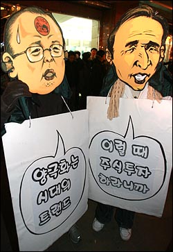 2008년 12월 6일 서울 명동에서 열린 '경제파탄 민주파괴 이명박 정권 심판 국민대회'에서 이명박 대통령과 강만수 장관 가면을 쓴 참가자들이 경제정책을 규탄하는 퍼포먼스를 벌이고 있다.