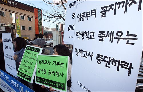  일제고사를 반대하는 학부모, 학생, 시민사회단체 회원들이 일제고사 중단을 촉구하는 팻말을 들고 있다. 