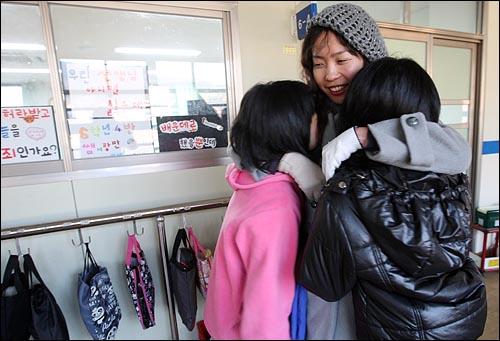 김윤주 교사가 교실에서 아이들을 얼싸안고 있다.