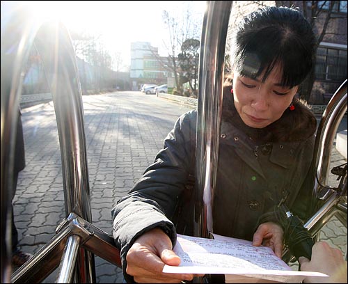 18일 오전 서울 광진구 광양중학교에서 윤여강 교사가 조회를 마친 뒤 학교 밖으로 나와 학부모로부터 받은 격려 편지를 읽으며 눈물을 흘리고 있다.