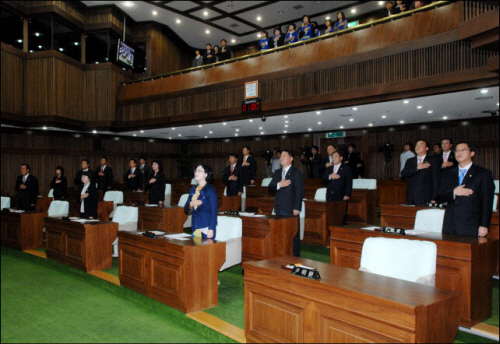 울산시의회 정례회에 앞서 국민의례를 하고 있는 시의원들 