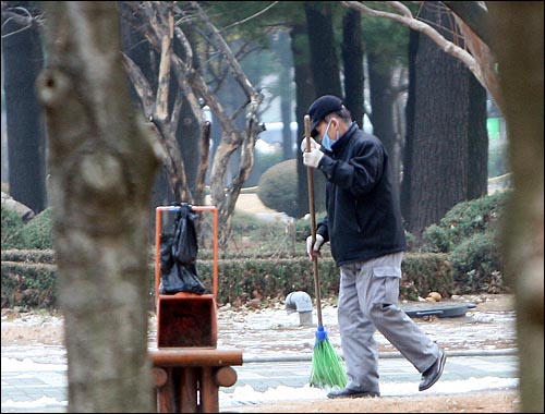 국회 청소용역 업체 환경미화원이 24일 오전 서울 여의도 국회 본청 앞에서 낙엽을 쓸고 있다(자료사진·사진에 찍힌 미화원은 기사의 내용과 관련 없습니다).