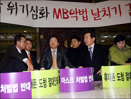민주당 의원들이 국회 본회의장을 기습 점거한 가운데 26일 오후 서울 여의도 국회 본회의장 앞에서 민주당 정세균 대표와 당지도부들이 연좌농성을 벌이고 있다.