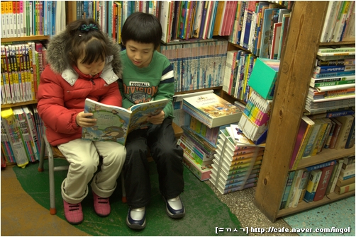 둘이 나란히 앉아서 책을 읽는 어린이. 둘은 남매일까요. 찍혀 주어서 고맙습니다. (인천 배다리 헌책방 〈아벨서점〉에서)