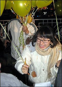 일제고사 대신 학생들과 체험학습을 선택해 해직당한 설은주 교사가 31일 밤 종로 보신각 앞에서 시민들에게 풍선을 나눠주고 있다.