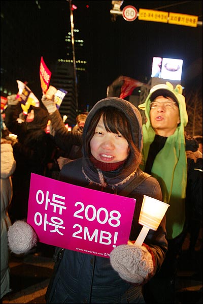 31일 밤 새해 보신각 타종식이 열리는 서울 종각 네거리에 모인 시민들이 '아듀 2008 아듀 MB!'가 적힌 종이 피켓을 들고 있다.