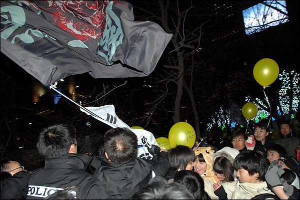 경찰이 31일 밤 종로 보신각 인근에서 한 인터넷 카페회원들의 들고있던 깃발과 태극기를 강제로 빼앗고 있다.
