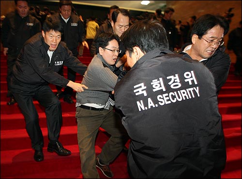 3일 밤 서울 여의도 국회에서 국회 경위들이 민주당 당직자를 끌어내고 있다.