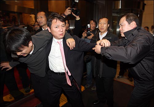 3일 밤 서울 여의도 국회에서 최재성 민주당 의원이 부상을 입은 당직자를 부축하고 본청으로 들어가려하자 경위(오른쪽)가 병원으로 가라며 끌어내고 있다.