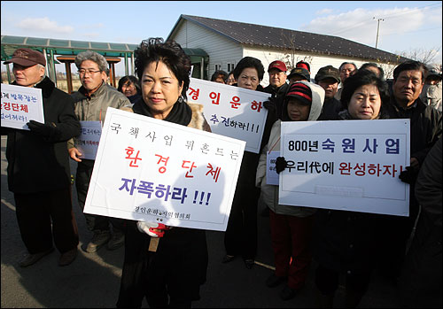  '경인운하 건설단' 현판식에 참석한 찬성측 주민들이 환경단체를 비난하는 피켓을 들고 있다.