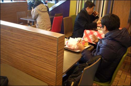 학원 수업을 끝마친 초등학생이 한 패스트푸드점에서 혼자 햄버거를 먹고 있다. 