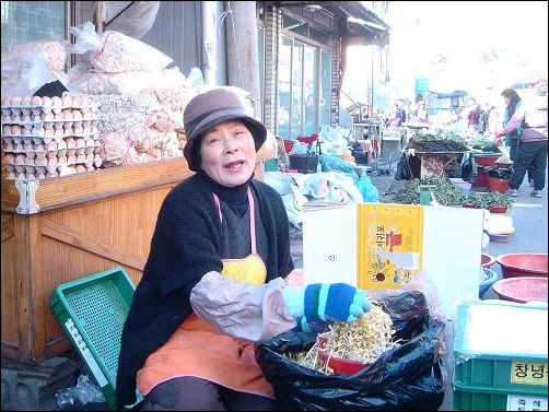 콩나물을 다듬고 있는 김삼순 씨 환한 웃음을 짓는 김삼순 씨, 무척이나 고아한 얼굴이다.