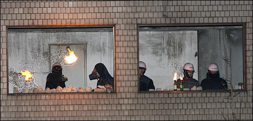 20일 새벽 서울 용산로 신용산역 부근 재개발지역 5층 건물에서 철거민들이 경찰을 향해 새총에 화염병을 걸어 던지고 있다.